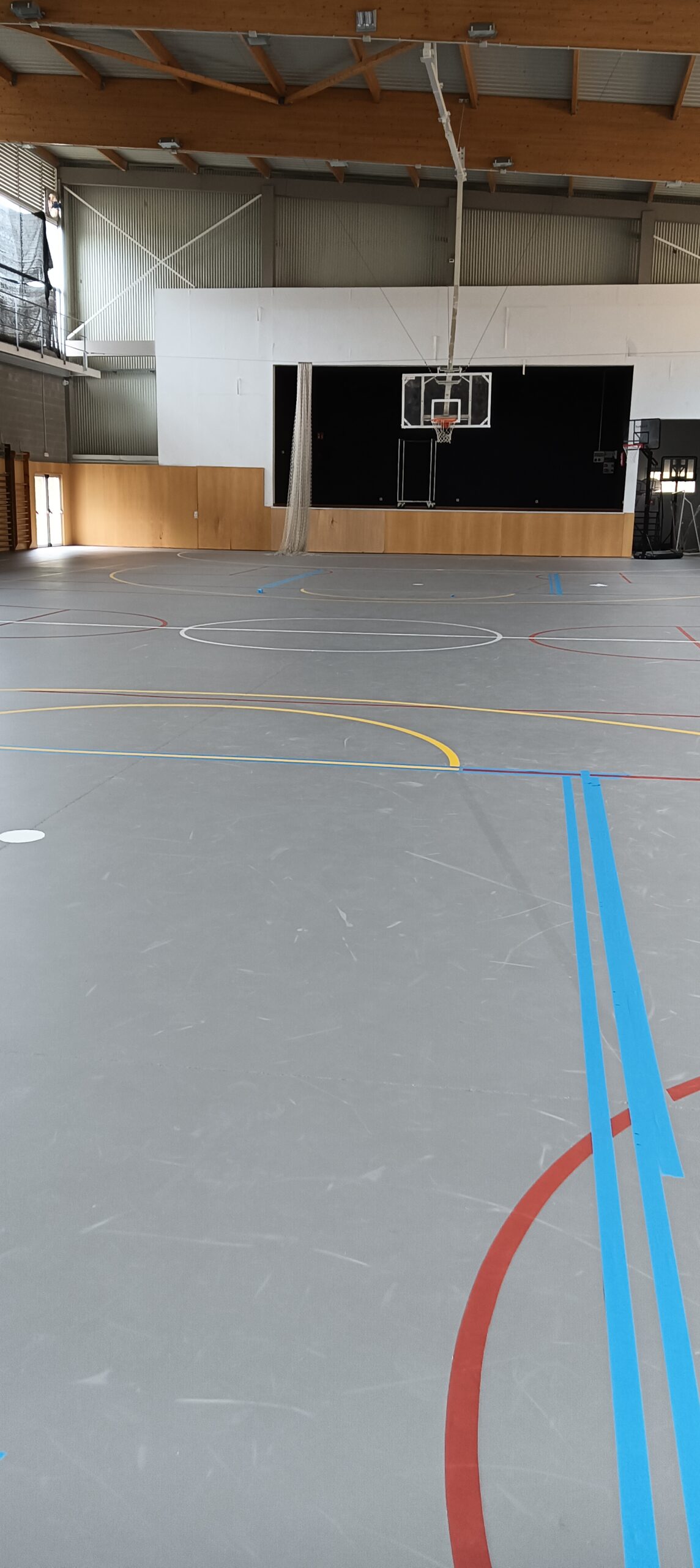 Pintor de Girona Pintors marcando las líneas de una pista deportiva durante la fase de ejecución del trabajo