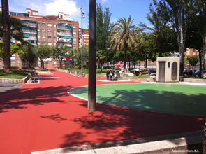 Parque urbano con caminos de caucho rojo y zona verde de juego