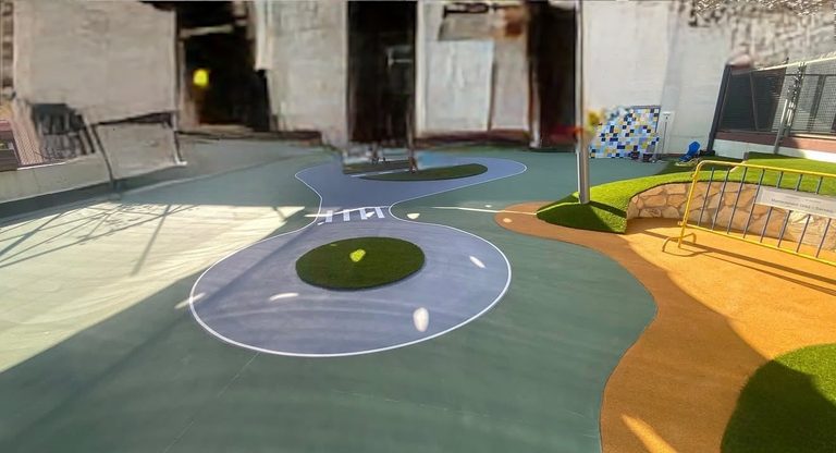 Patio de un centro educativo con la superficie pintada y el marcaje de juegos en el suelo