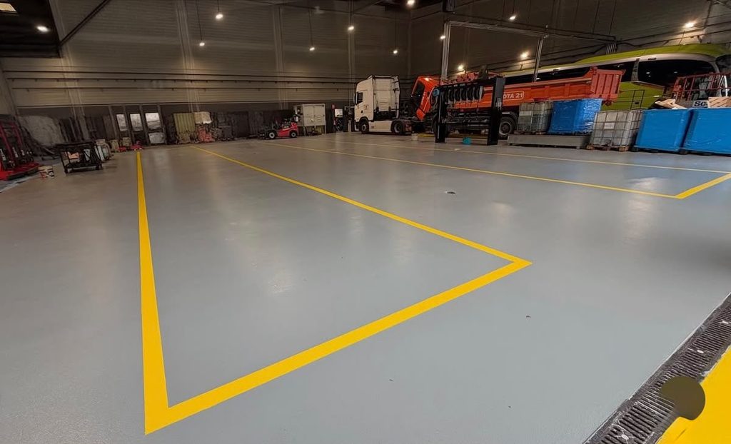 Pavimento de resina claro con marcado amarillo para delimitar zonas